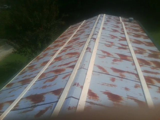 Rusted metal roof panels with new wood purlins before replacement — Storm Damage Roof Repair in Street by Roofing Brothers