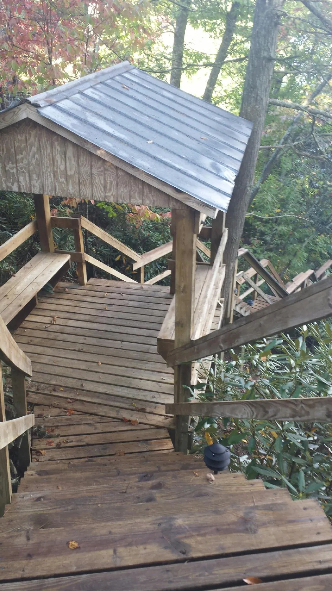 Metal roofed shelter over wooden steps on a wooded walkway — Skylight Repair & Installation work by our crew in Street